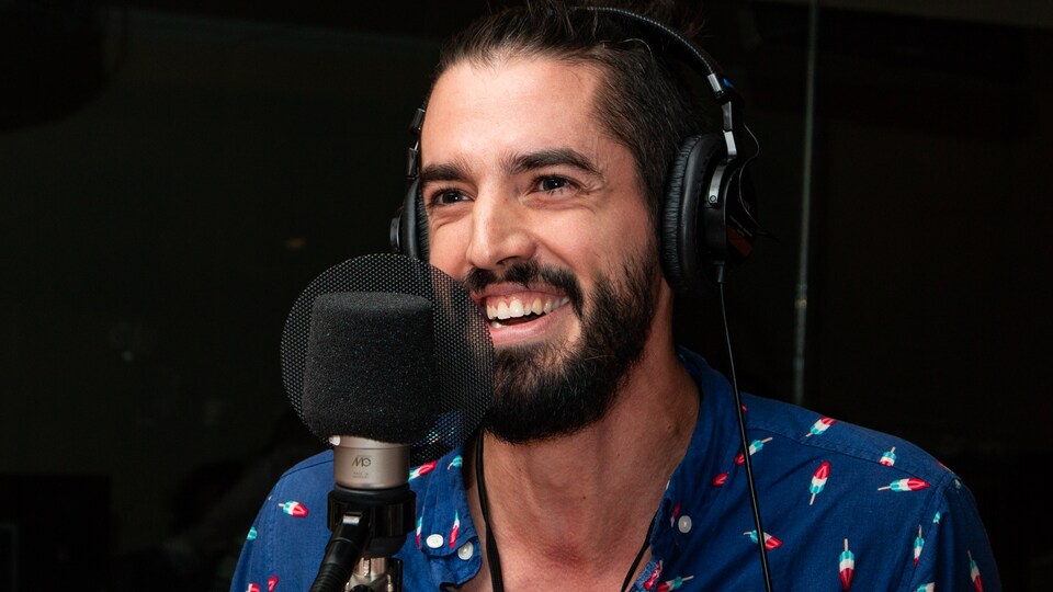 L'artiste barbu sourit à pleines dents au micro de l'émission.