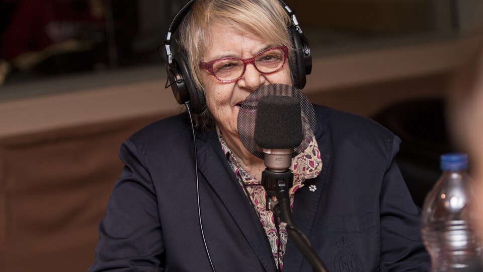 Elle sourit à la caméra.