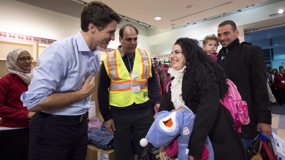 Le premier ministre Justin Trudeau accueille des réfugiés syriens le 11 décembre 2015 à l'aéroport international Pearson de Toronto.
