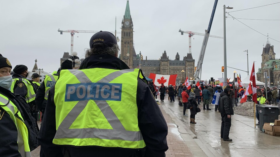 Des policiers devant des manifestants devant le parlement à Ottawa.