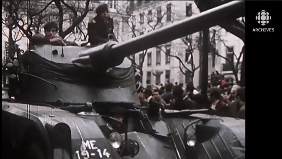 Deux soldats installés dans la tourelle d'un blindé sont entourés par la foule à Lisbonne. 