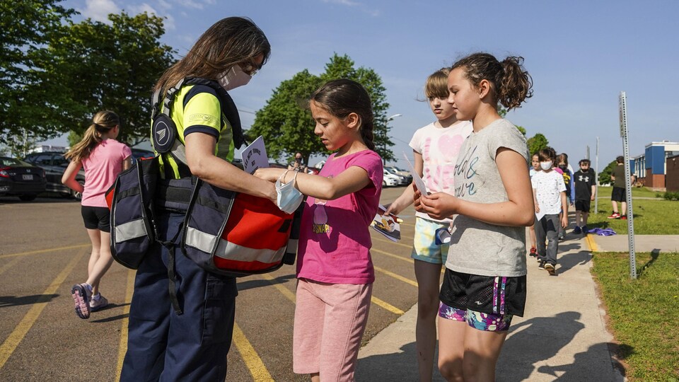 Des enfants donnent des lettres à une employée de Poste Canada.