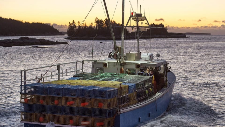 Le bateau vogue sur l'eau alors que le soleil se lève.