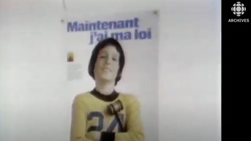 Affiche montrant un jeune garçon vêtu d'un t-shirt arborant le chiffre 24 et qui tient un maillet symbolisant la justice.