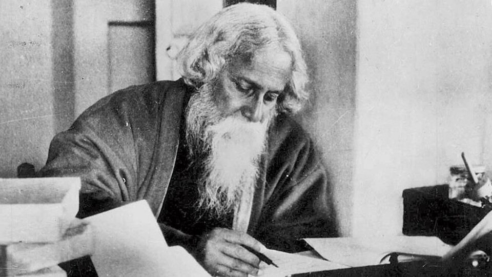 Un homme barbu en session d'écriture.