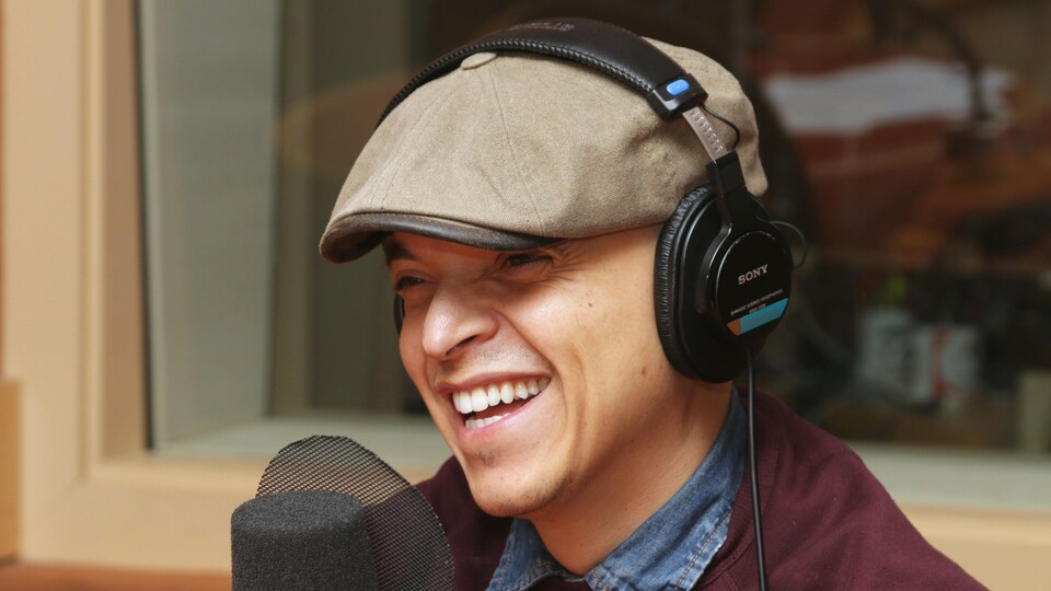 Photo de Rachid Badouri devant un micro de radio.
