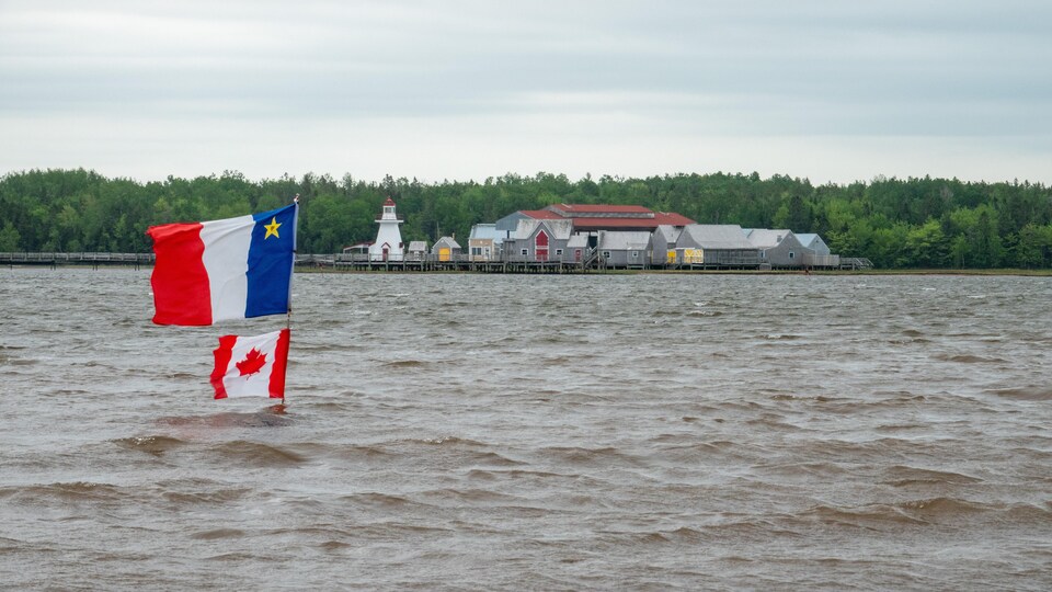 Vue du site Le Pays de la Sagouine avec en avant-plan les drapeaux acadien et canadien.