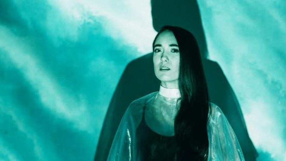 La chanteuse devant un mur turquoise