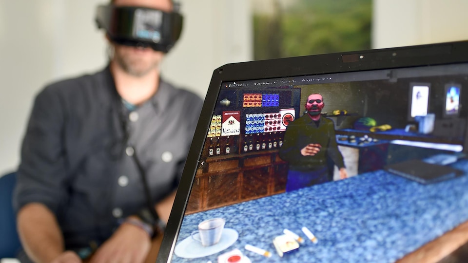 Un homme porte des lunettes de réalité virtuelle. Devant lui, sur une table, se trouve un ordinateur portable avec l'image d'un homme derrière un comptoir.