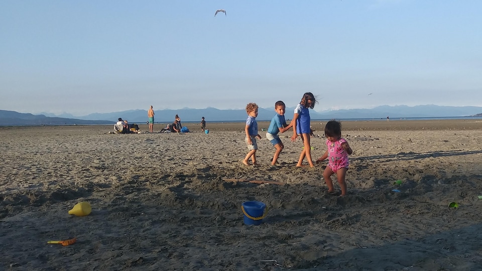 Des enfants jouent sur une plage.