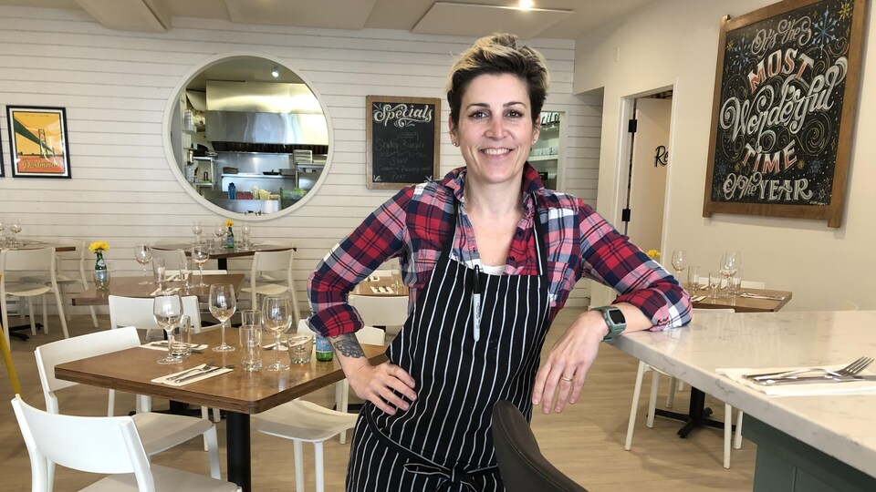 Renée Lavallée, souriante au bout du bar de son restaurant.