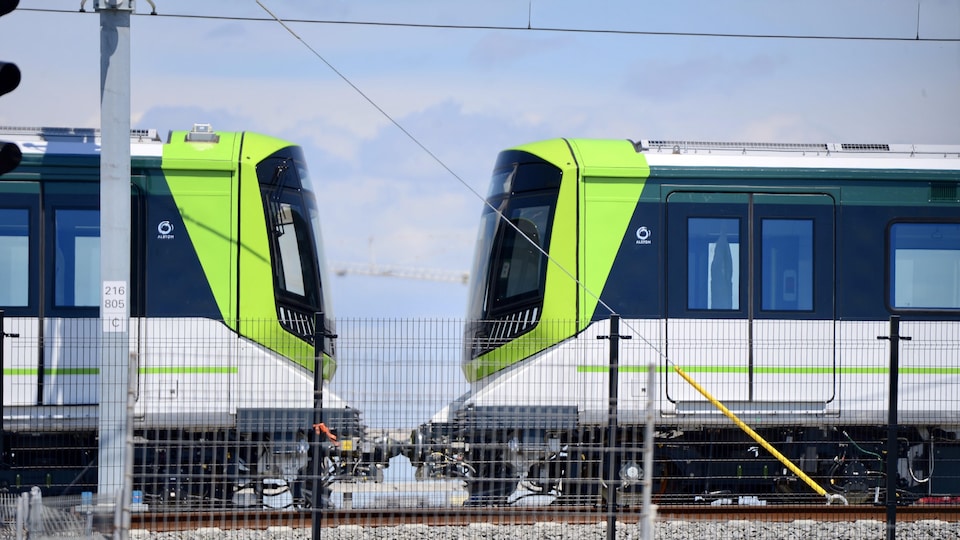 Gros plan sur deux voitures du REM sur les rails.