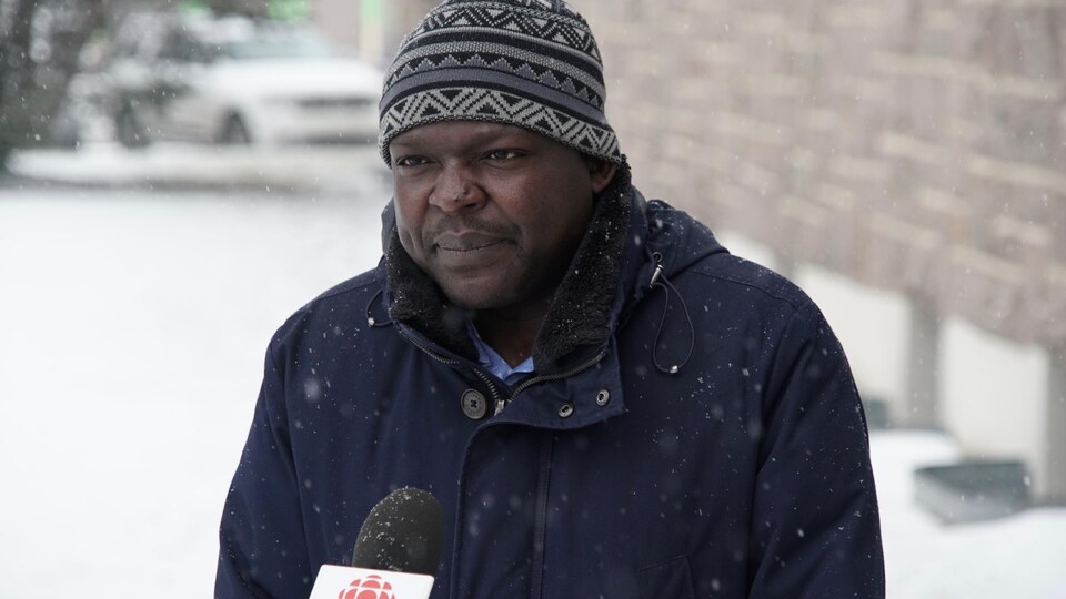 Richard Fachehoun accorde une entrevue à Radio-Canada sous la neige. 