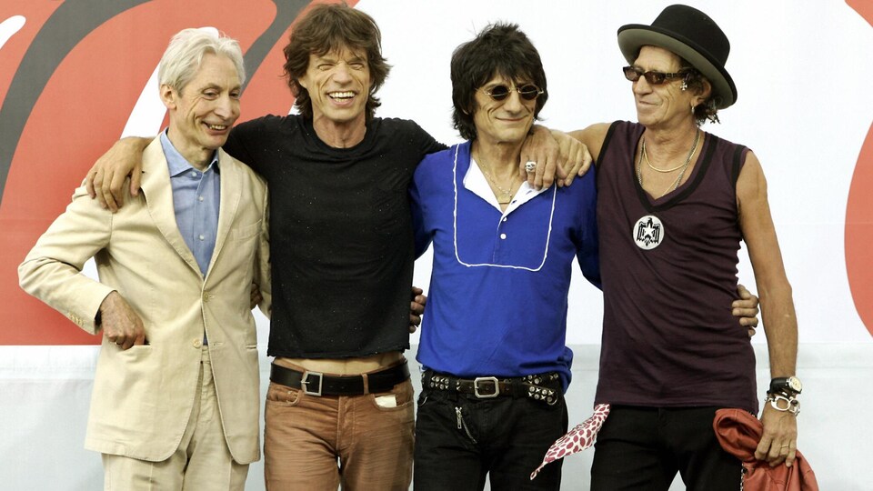 Charlie Watts, Mick Jagger, Ron Wood et Keith Richards se tiennent par les épaules et posent en conférence de presse.