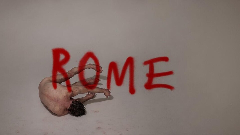 Image représentant un être nu de dos comme tombé par terre avec écrit en style graffiti ROME.
