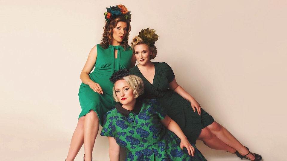 Trois femmes sont posées en costumes d'époque.
