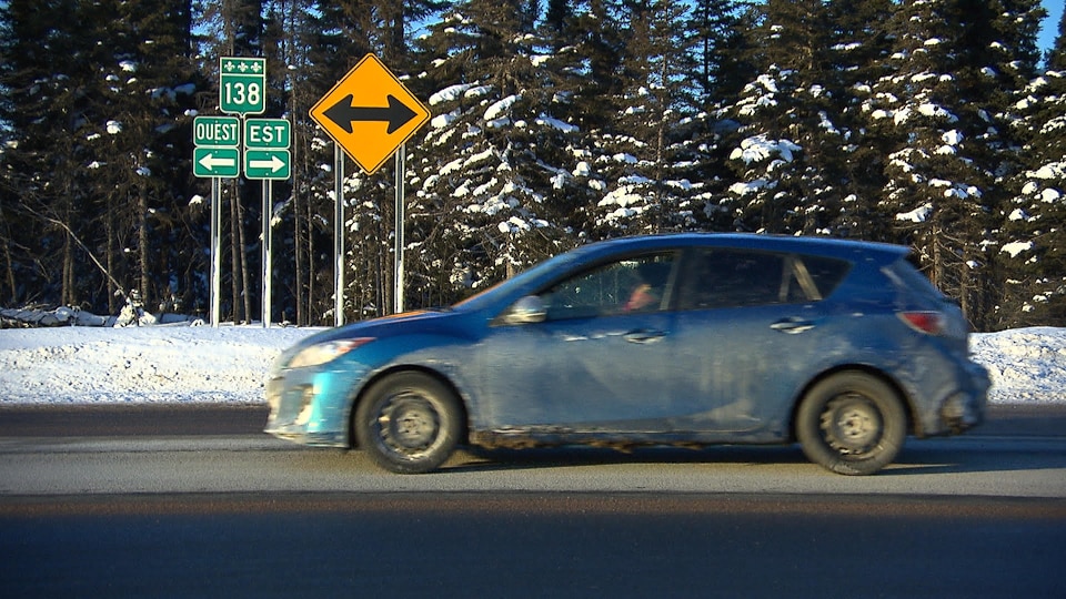 Route 138, sur la Côte-Nord : voiture avec panneaux de signalisation