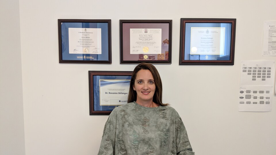 La chercheuse et orthophoniste Roxanne Bélanger assise dans son bureau devant ses diplômes.
