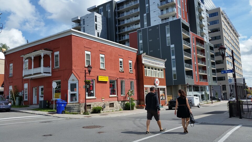 Deux piétons marchant au coin des rues Wright et Eddy.
