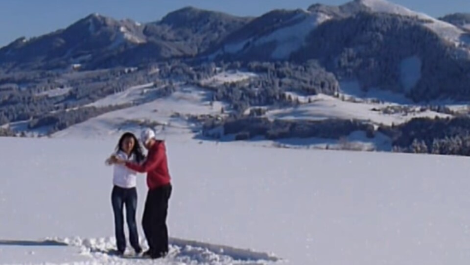Un couple danse la salsa dans la neige sur fond de montagnes enneigées