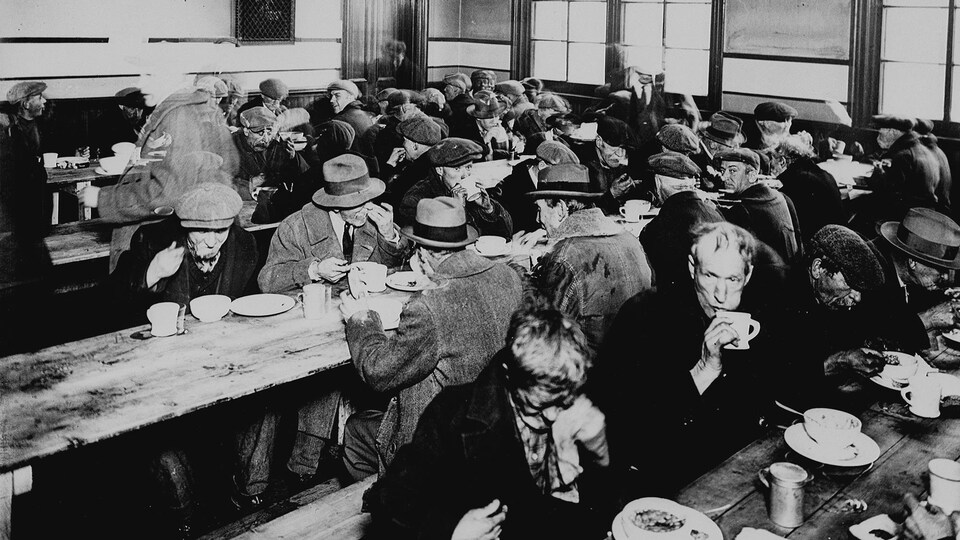 Des personnes mangent dans une soupe populaire des années 1930.