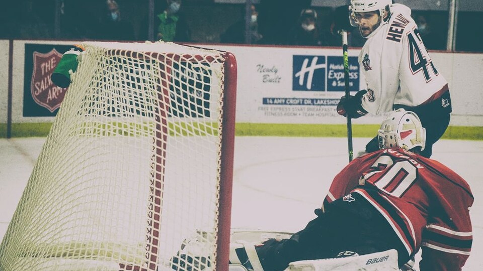 Un joueur de hockey marque un but.