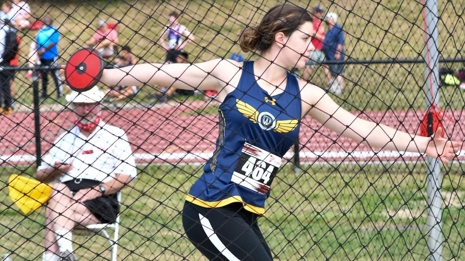 Une jeune athlète qui s'apprête à lancer un disque en athlétisme.