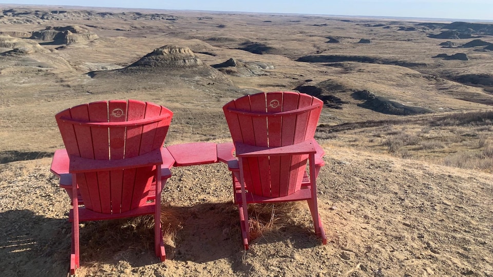 Deux chaises rouges font face au parc des Prairies.