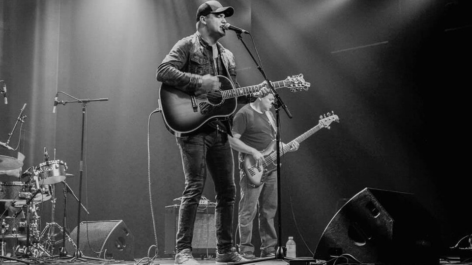 L'auteur-compositeur-interprète Scott-Pien Picard sur scène, avec sa guitare.