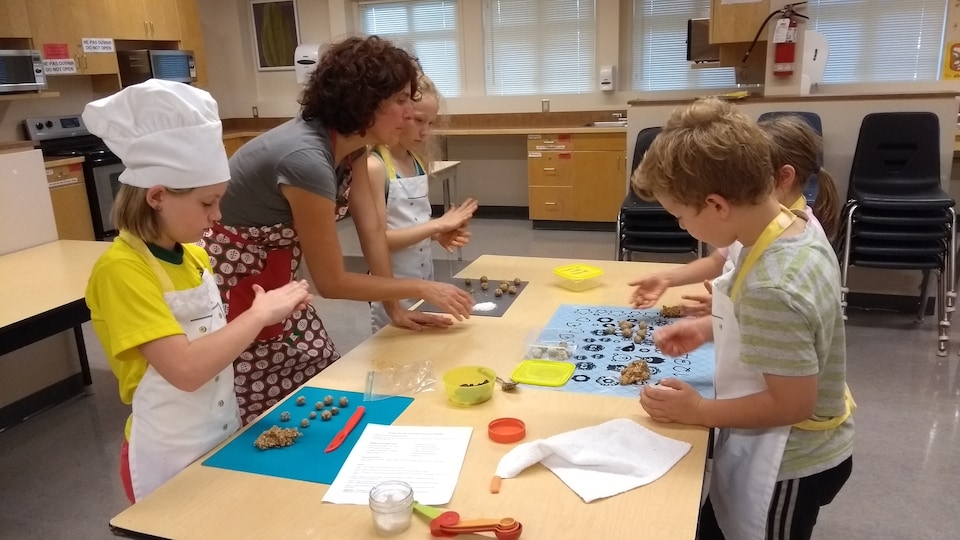 des enfants cuisinent dans une salle de classe