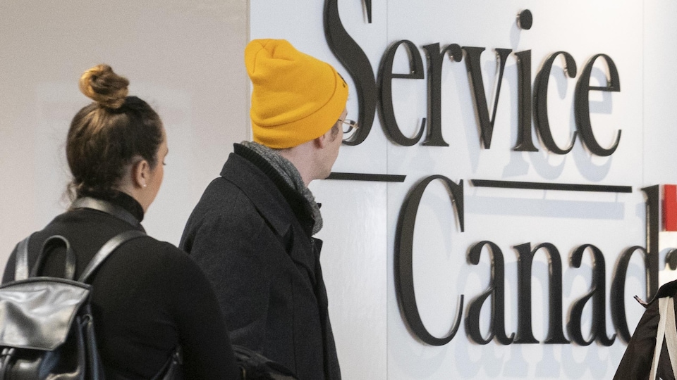 Des gens font la queue dans un bureau de Service Canada.