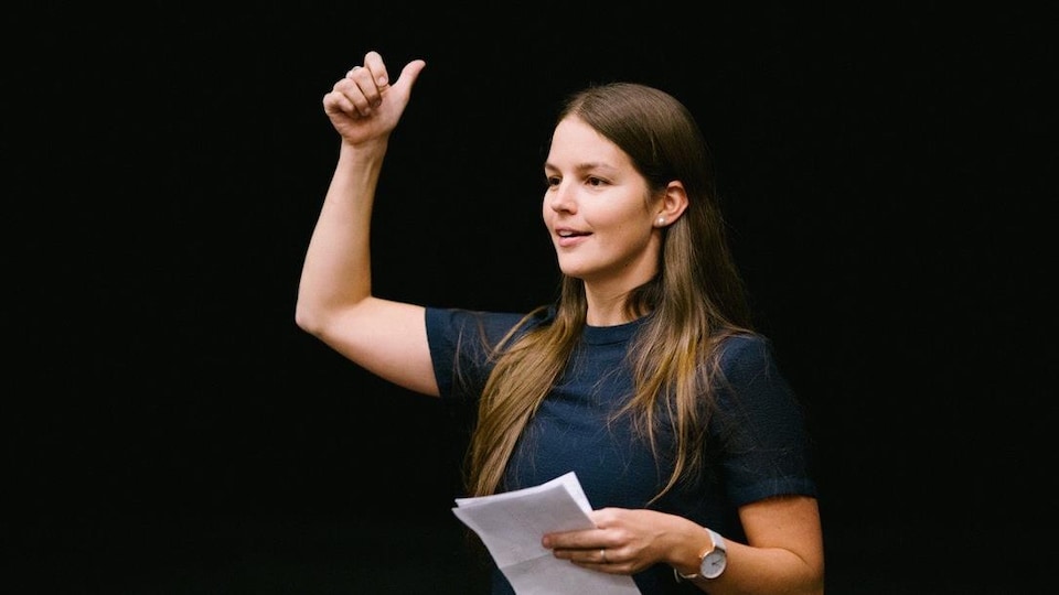 Sophie Audet, une jeune femme brune et souriante qui fait un discours sur scène.