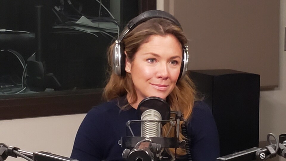 Une femme devant un micro de radio