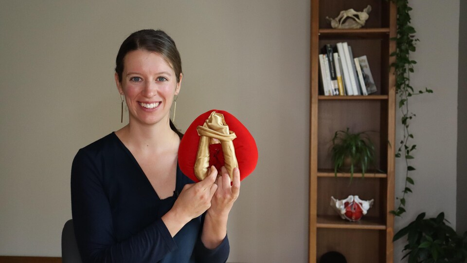 une femme tenant une maquette d'une vulve.