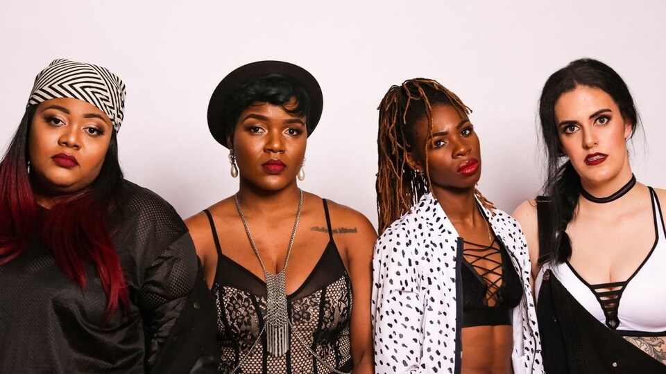 Les quatre femmes du collectif rap The Sorority devant un mur blanc.