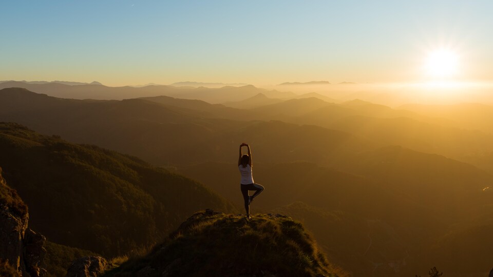 Une yogi au somment d'une montagne. 