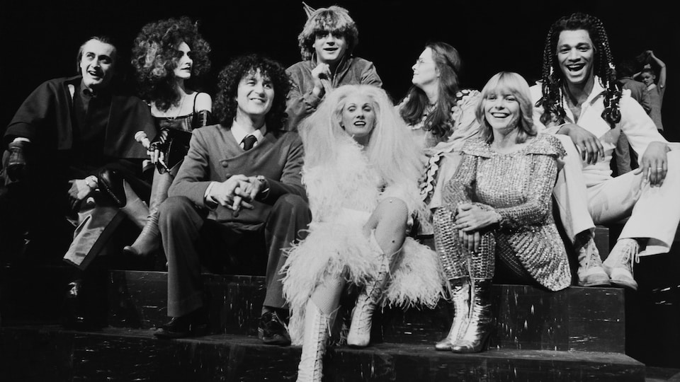 Image de scène en noir et blanc avec les interprètes en costumes.