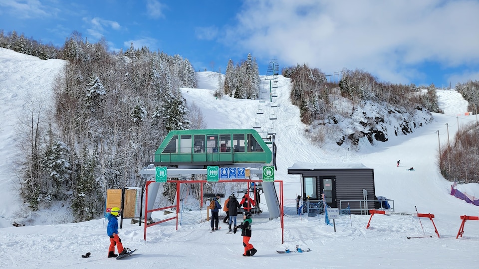 La montagne de ski Gallix enneigée, avec des skieurs, planchistes et le télésiège.