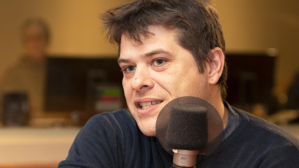 Le chef Stéphane Modat parle dans un studio de radio.