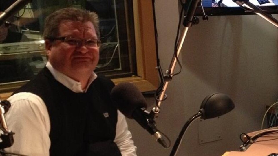 Plan moyen de Stéphane Dorge assis dans un studio radio.