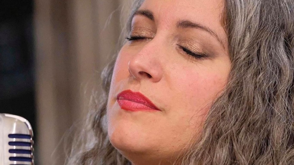 L'artiste chante une mélode les yeux fermés.