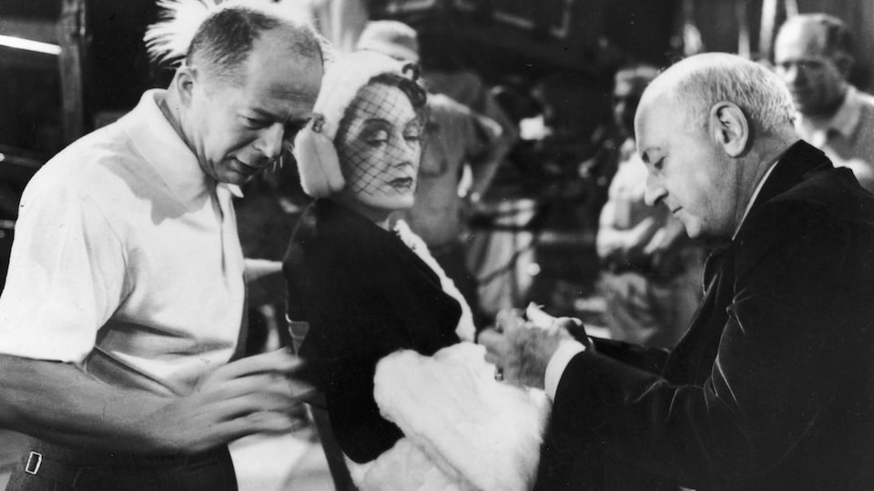 Le réalisateur d'origine autrichienne Billy Wilder (à gauche) et le réalisateur américain Cecil B. DeMille se tiennent de chaque côté de l'acteur américain Gloria Swanson sur le tournage du film Sunset Boulevard, en 1950.