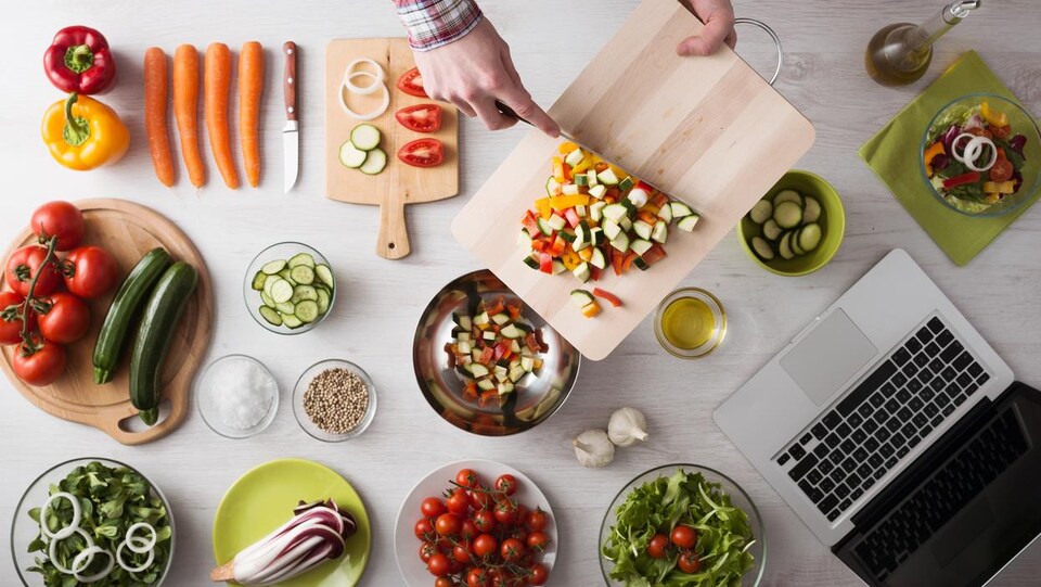 Des plats de légumes avec un ordinateur portable sur un comptoir