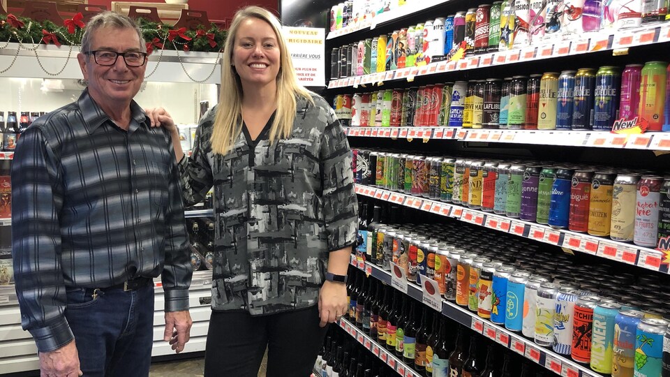 Gabriel et Nadine devant la diversité des bières offertes à leur commerce.
