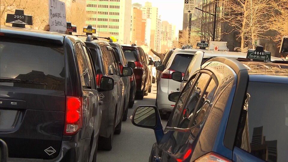 Deux rangées de voitures taxi obstruant la circulation