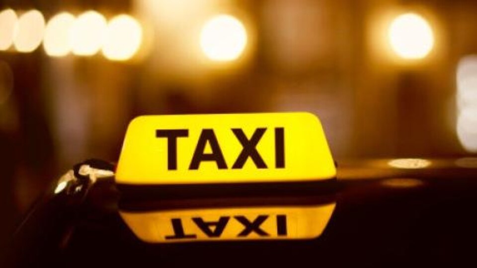 Signe d'un taxi illuminé dans la nuit.
