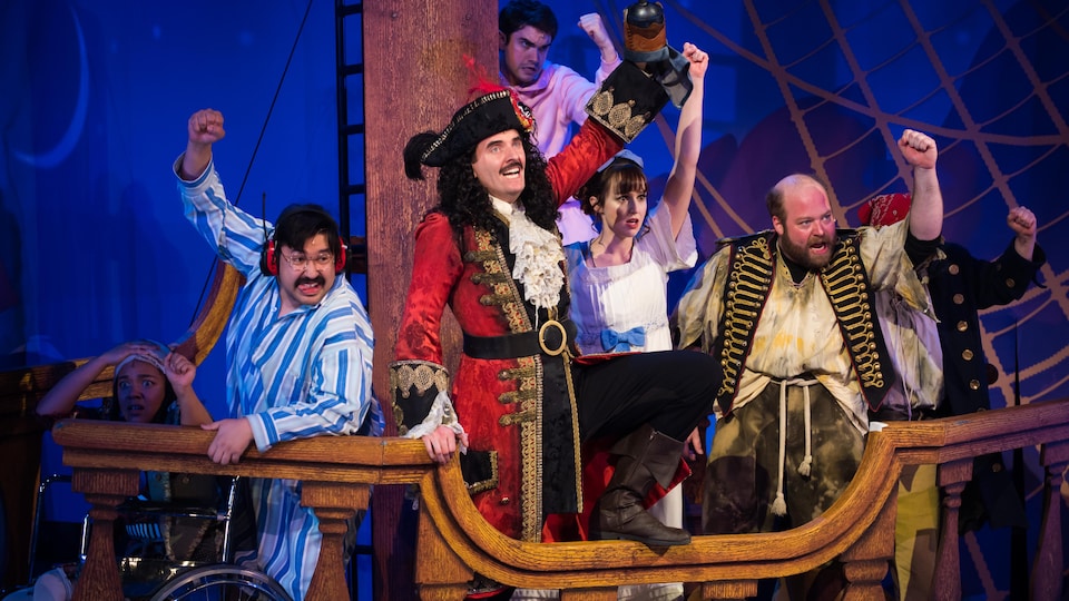 Des comédien déguisés en pirates sur une scène qui ressemble à un bateau.
