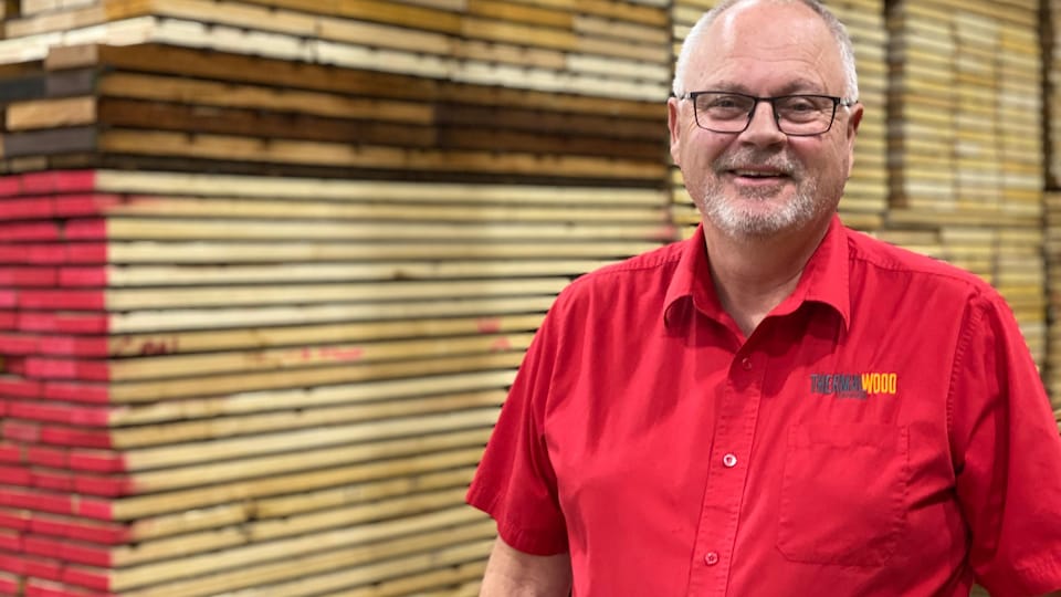 Robert Lennon debout devant des planches de bois.