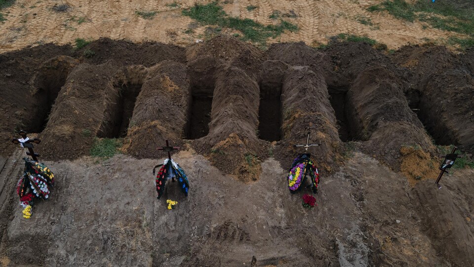 Des fosses communes où l'on voit des croix.