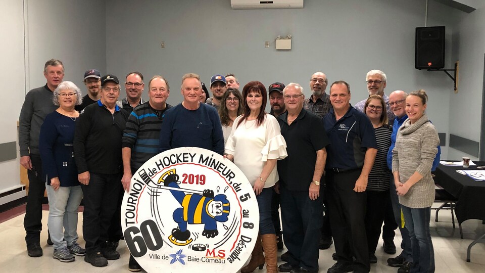 Le comité organisateur du 60e Tournoi de hockey mineur de Baie-Comeau en compagnie du président d'honneur, Fernand Leblanc.